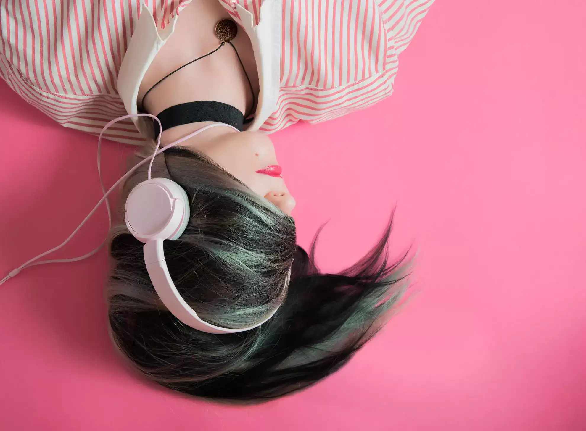 uma garota com fones de ouvido rosa